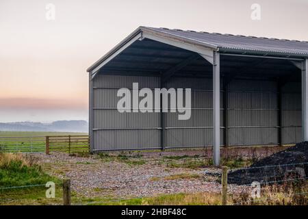 Grande grange vide ondulée avec fond peu de nuages et coucher de soleil, Wiltshire Royaume-Uni Banque D'Images