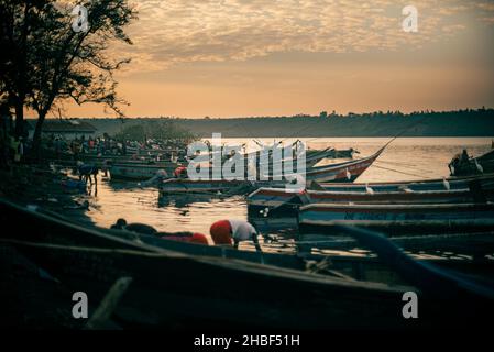 Les bateaux se sont amarrés sur le banc de la rivière contre un ciel nuageux au coucher du soleil Banque D'Images