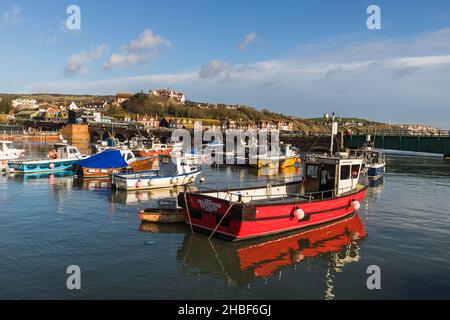 Des bateaux de pêche vus amarrés dans le port intérieur de Folkstone avec l'ancien pont ferroviaire disused en arrière-plan, pris le 4th décembre 2021. Banque D'Images