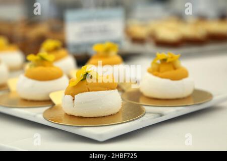 Magnifique plateau élégant de canapés au citron meringue.Nourriture prête pour une fête dans le jardin, un mariage ou un événement spécial.Décoration avec pétales. Banque D'Images