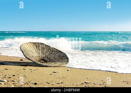 reed beach parasol dans le surf, soufflé par le vent pendant une tempête Banque D'Images