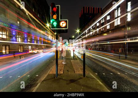 Des pistes lumineuses à longue exposition depuis les bus et autres véhicules en mouvement sur Portland Street, Manchester, Angleterre, Royaume-Uni Banque D'Images