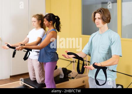 Adolescents d'entraînement pilates dans la salle de gym avec entraîneur Banque D'Images