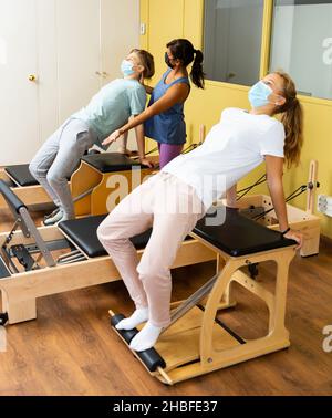 Adolescents dans les masques d'entraînement pilates dans la salle de gym avec traine Banque D'Images