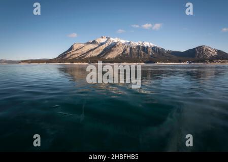 Mont Michener en fin d'après-midi, la lumière se reflète sur la surface gelée du lac Abraham dans les Rocheuses canadiennes. Banque D'Images