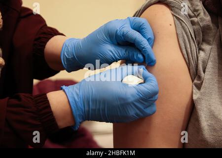 Londres, Royaume-Uni.15th novembre 2021.Un travailleur de la santé dépose un plâtre après avoir administré un vaccin de rappel Pfizer/BioNTech Covid-19 à une femme dans un centre de vaccination.le gouvernement met actuellement en place un programme de vaccination de rappel en offrant un vaccin Covid-19 à toute personne âgée de plus de 18 ans, d'ici la fin du mois de décembre.(Image de crédit : © Dinendra Haria/SOPA Images via ZUMA Press Wire) Banque D'Images