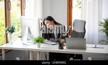 Femme d'affaires fatiguée fatiguée du travail financier.Entrepreneur épuisé souffrant d'une longue utilisation d'ordinateur dans le bureau. Banque D'Images