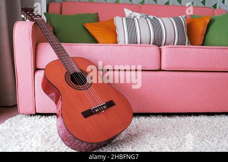 Guitare acoustique classique dans l'intérieur rose.Arrière-plans de passe-temps Banque D'Images