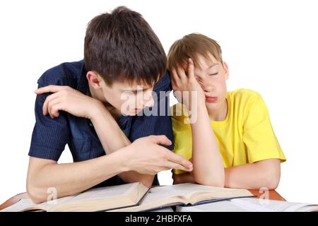 Frère aîné et enfant d'Annoyed sur le bureau d'école sur fond blanc Banque D'Images