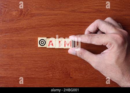 Ambition, mission et concept objectif.Cubes en bois avec texte AIM et tir à l'arc cible avec icône de flèches. Banque D'Images