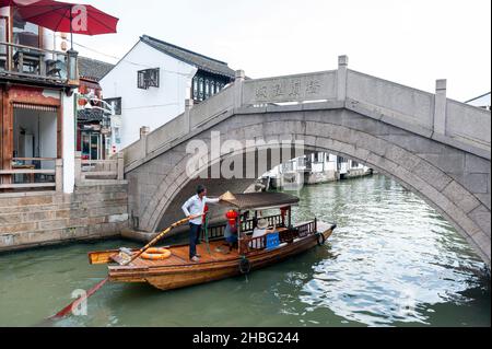 Croisière touristique en barque en bois un vieux pont en pierre se trouve au-dessus d'un canal dans la vieille ville aquatique de Zhujiajiao, un village historique de Shanghai, en Chine Banque D'Images