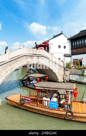 Croisière touristique en barque en bois un vieux pont en pierre se trouve au-dessus d'un canal dans la vieille ville aquatique de Zhujiajiao, un village historique de Shanghai, en Chine Banque D'Images