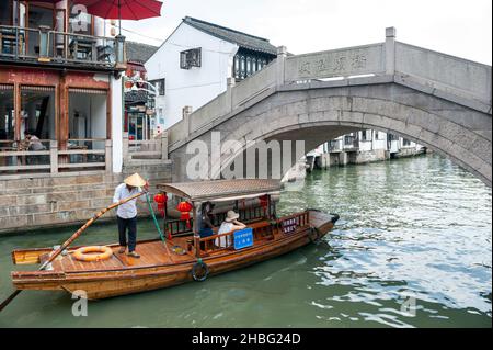 Croisière touristique en barque en bois un vieux pont en pierre se trouve au-dessus d'un canal dans la vieille ville aquatique de Zhujiajiao, un village historique de Shanghai, en Chine Banque D'Images