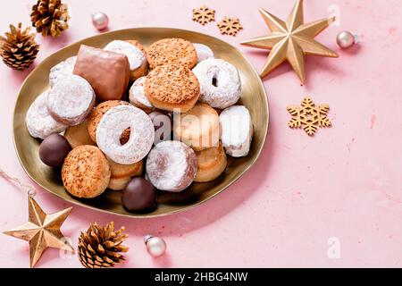 Les délices des fêtes polvorones et les mantecados bordent en plaque dorée sur une table rose décorée de boules dorées et de cônes de pin, bannière web, espace copie Banque D'Images