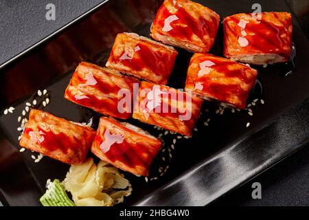 Petits pains à sushi au saumon poêlé avec sauce unagi et sésame servis avec du gingembre mariné et du wasabi Banque D'Images