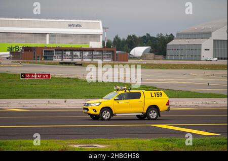 Riga, Lettonie - 31 août 2021 : voiture jaune de contrôle des oiseaux d'aviation à l'aéroport international de Riga (RIX) Banque D'Images