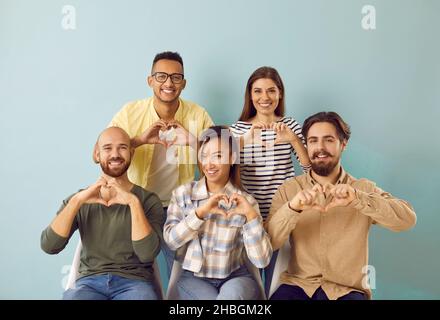 Groupe de personnes diversifiées et heureuses faisant le geste de forme de coeur comme symbole de l'amour et de la gratitude Banque D'Images