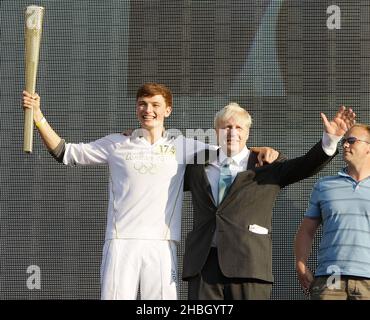 Tyler Rix et le maire Boris Johnson avec la torche olympique au concert de relais de la flamme olympique de Coca-Cola en 2012 à Hyde Park à Londres. Banque D'Images