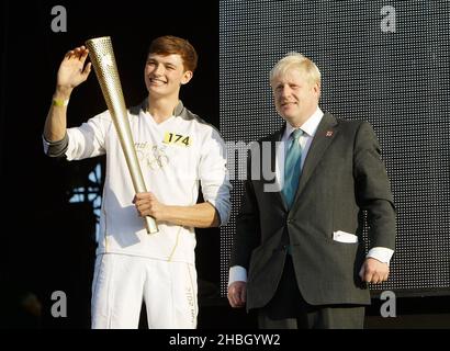 Tyler Rix et le maire Boris Johnson avec la torche olympique au concert de relais de la flamme olympique de Coca-Cola en 2012 à Hyde Park à Londres. Banque D'Images