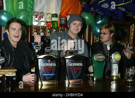 Westlife tire des pintes au pub O'Neills à Wardour St, le jour de la St Patrick, Londres, longueur 3/4 Banque D'Images