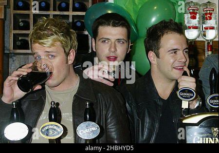 Westlife tire des pintes au pub O'Neills à Wardour St, le jour de la St Patrick, Londres, longueur 3/4 Banque D'Images