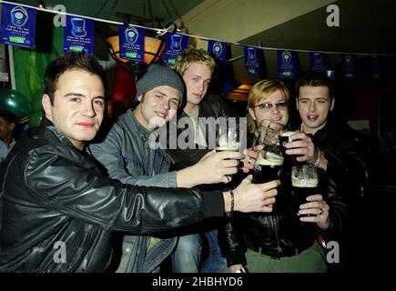 Westlife tire des pintes au pub O'Neills à Wardour St, le jour de la St Patrick, Londres, longueur 3/4 Banque D'Images