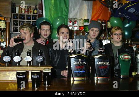 Westlife tire des pintes au pub O'Neills à Wardour St, le jour de la St Patrick, Londres, longueur 3/4 Banque D'Images