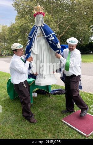 À la fin d'un service de plein air, les fidèles de l'Apostolat mondial de Saint Michel retirent une statue de la Vierge Marie de l'autel. Dans Queens NYC Banque D'Images