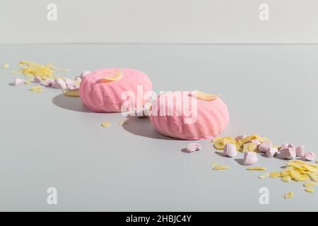 Zefir de guimauve rose sur fond de papier gris avec amandes Banque D'Images