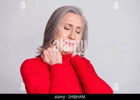Photo de femme âgée mains toucher cou malheureux spasme mal mal mal mal douleur souffrent isolé sur fond de couleur grise Banque D'Images