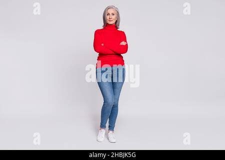 Photo pleine longueur de femme belle senior sourire positif heureux croisé mains confiantes isolé sur fond gris couleur Banque D'Images