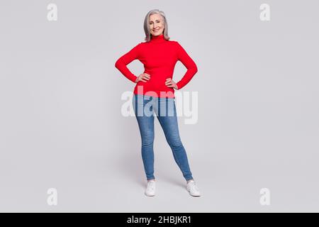 Photo pleine longueur de la femme âgée joyeuse sourire positif confiant isolé sur fond gris couleur Banque D'Images