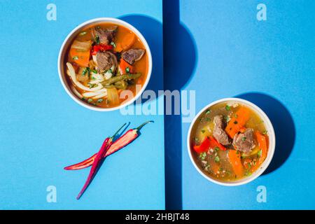 Soupe traditionnelle asiatique, ouzbek, Moyen-Orient avec bœuf ou agneau et légumes.Shorpa, sherpa, chorba sur bleu Banque D'Images