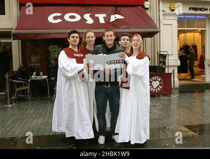 Lee Ryan rejoint ses nouveaux « amis du groupe » pour carol Singing à Costa, Argyll Street, Londres. Banque D'Images