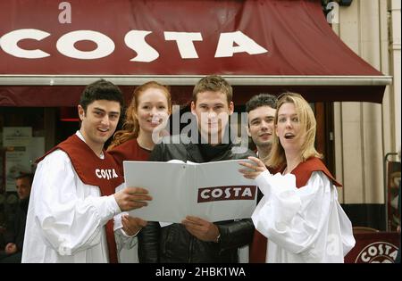 Lee Ryan rejoint ses nouveaux « amis du groupe » pour carol Singing à Costa, Argyll Street, Londres. Banque D'Images