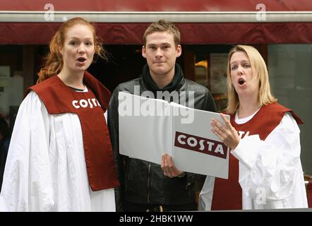 Lee Ryan rejoint ses nouveaux « amis du groupe » pour carol Singing à Costa, Argyll Street, Londres. Banque D'Images