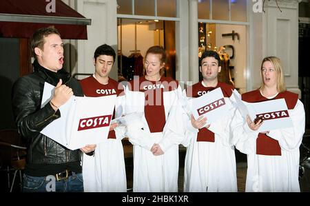 Lee Ryan rejoint ses nouveaux « amis du groupe » pour carol Singing à Costa, Argyll Street, Londres. Banque D'Images