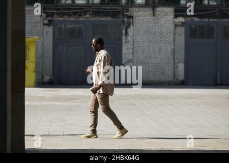 Photo grand angle d'un homme afro-américain adulte marchant dans une rue urbaine, espace de copie Banque D'Images