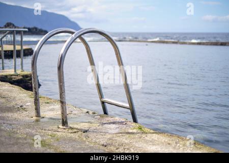 Gros plan d'une échelle métallique menant à l'étang de mer naturel de la Maceta sur El Hierro.Baignade et loisirs dans les piscines d'eau de mer de l'île des Canaries Banque D'Images