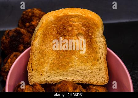 Un gros plan de boulettes de viande fraîchement frites avec du pain grillé dans un bol Banque D'Images