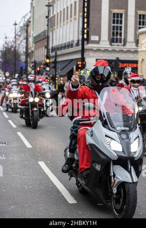 Les motards en costume de Santa défilent sur Oxford Street à l'approche du jour de Noël, tandis que les caisses Omicron continuent à s'envolent avant les fêtes de fin d'année. Banque D'Images