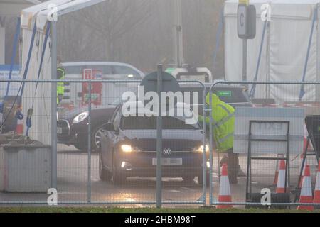 La photo datée du 19th 2021 décembre montre la conduite animée des covid dans le centre d'essais de Milton, Cambridge, sous les projecteurs un dimanche matin brumeux pendant que les gens vont pour leurs tests PCR.À mesure que les cas Omicron augmentent, la demande de tests augmente et certaines personnes ne peuvent pas réserver une fente pour un test ou obtenir des kits de tests à domicile. Banque D'Images