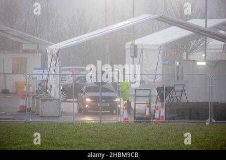 La photo datée du 19th 2021 décembre montre la conduite animée des covid dans le centre d'essais de Milton, Cambridge, sous les projecteurs un dimanche matin brumeux pendant que les gens vont pour leurs tests PCR.À mesure que les cas Omicron augmentent, la demande de tests augmente et certaines personnes ne peuvent pas réserver une fente pour un test ou obtenir des kits de tests à domicile. Banque D'Images