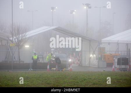 La photo datée du 19th 2021 décembre montre la conduite animée des covid dans le centre d'essais de Milton, Cambridge, sous les projecteurs un dimanche matin brumeux pendant que les gens vont pour leurs tests PCR.À mesure que les cas Omicron augmentent, la demande de tests augmente et certaines personnes ne peuvent pas réserver une fente pour un test ou obtenir des kits de tests à domicile. Banque D'Images