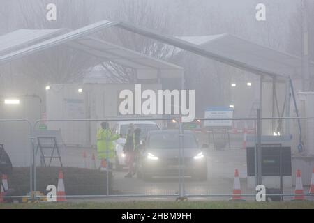 La photo datée du 19th 2021 décembre montre la conduite animée des covid dans le centre d'essais de Milton, Cambridge, sous les projecteurs un dimanche matin brumeux pendant que les gens vont pour leurs tests PCR.À mesure que les cas Omicron augmentent, la demande de tests augmente et certaines personnes ne peuvent pas réserver une fente pour un test ou obtenir des kits de tests à domicile. Banque D'Images