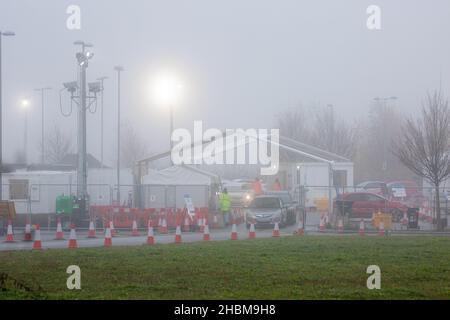 La photo datée du 19th 2021 décembre montre la conduite animée des covid dans le centre d'essais de Milton, Cambridge, sous les projecteurs un dimanche matin brumeux pendant que les gens vont pour leurs tests PCR.À mesure que les cas Omicron augmentent, la demande de tests augmente et certaines personnes ne peuvent pas réserver une fente pour un test ou obtenir des kits de tests à domicile. Banque D'Images