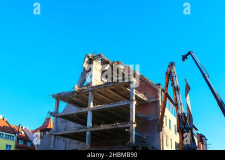 Démolition d'un bâtiment dans la ville .Déconstruction de la machine de concasseur hydraulique .Maison en ruines Banque D'Images