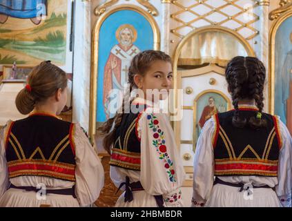 Salaj, Roumanie-15 mai 2018 : jeunes filles portant des costumes roumains traditionnels priant dans une église de la région de Transylvanie, Roumanie. Banque D'Images