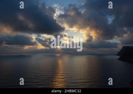 Un orage dans la lumière orange-jaune du coucher de soleil.Ciel étoilé spectaculaire.Énormes cumulus nuages au-dessus de l'océan.Un signe avant-coureur de mauvais temps, climat chan Banque D'Images