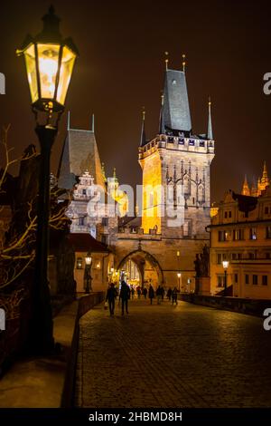 Prague, République Tchèque - Desember 8, 2021: Personnes sur le pont Charles avec éclairage de nuit en hiver Banque D'Images